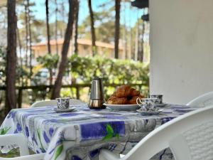 a table with a blue and white table cloth and a plate of bread at Villa Giorgio 1 relax in pineta in Bibione
