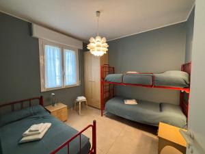 a bedroom with two bunk beds and a chandelier at Villa Giorgio 1 relax in pineta in Bibione