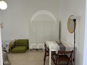 a living room with a table and a green couch at Casa Mireya - Spiaggia a 50m - by Cala Salento in Porto Cesareo