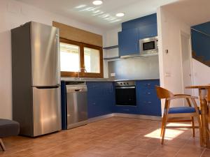 a kitchen with blue cabinets and a stainless steel refrigerator at Can Pirrot Salitja in Salitja