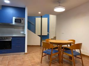 uma cozinha com armários azuis e uma mesa e cadeiras em Can Pirrot Salitja em Salitja