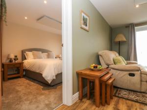 a bedroom with a bed and a chair and a table at Tractor Shed in Penryn