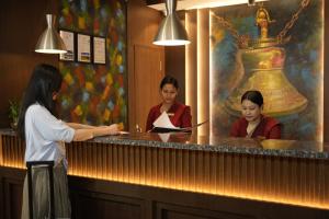 a woman standing at a counter in a restaurant at Lakhey Hotel in Kathmandu