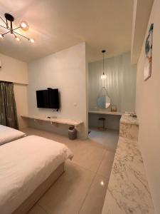 a bedroom with a bed and a tv on a wall at 近台東火車站 樂典 樂欣 配合補助 包棟 自由行 有車位 in Taitung City