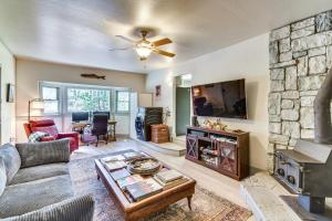 a living room with a fireplace and a stone wall at Lake Access & Hot Tub: Pet-Friendly Arnold Home in Arnold