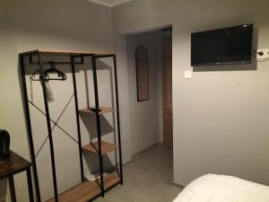 Ein Zimmer mit einem Schlafzimmer und einem Fernseher an der Wand in der Unterkunft Niehler Hotel in Köln