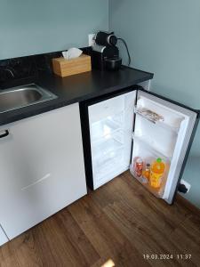 華沙的住宿－Apartament Magnolia，厨房配有带饮品的开放式冰箱