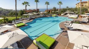 einen Pool in einem Resort mit Sonnenschirmen in der Unterkunft The Exclusive Marriott's Newport Coast Villas in Newport Beach