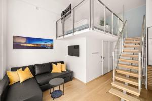 sala de estar con sofá negro y escalera en Dinbnb Apartments I 500m to Oslo Central Station I Roof Terrace I Free Gym, en Oslo