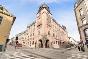 a large building with a clock tower on a street at Dinbnb Apartments I 500m to Oslo Central Station I Roof Terrace I Free Gym in Oslo