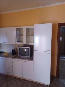 Il comprend une cuisine équipée d'un réfrigérateur blanc et une télévision. dans l'établissement Holiday Homes, à Campofelice di Roccella