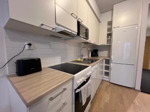 cocina pequeña con fregadero y fogones en Saunallinen keskustayksiö ja ilmainen yksityinen parkkipaikka en Turku