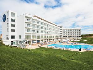 een hotel met een groot zwembad voor een gebouw bij MH Peniche in Peniche