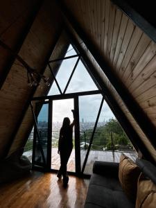 a woman standing in front of a large window at A-Frame Rest-Art in Batumi