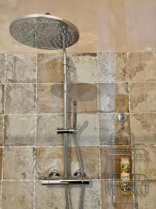 a shower with a shower head on a tile wall at Villa Sibilla in Barga