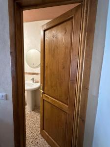 Łazienka z drewnianymi drzwiami i umywalką w obiekcie Villa Sibilla w mieście Barga