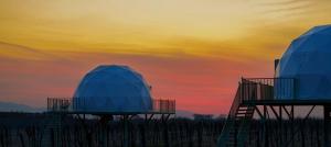 two domed observatories with a sunset in the background at Chateau Vartsikhe in Varts'ikhe