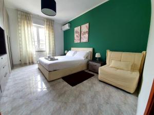 a green bedroom with a bed and a couch at enea apartment in Rome