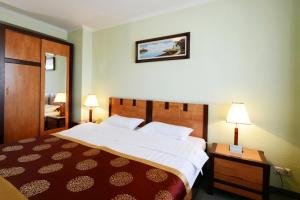 a hotel room with a large bed and two lamps at Narantuul Hotel in Ulaanbaatar