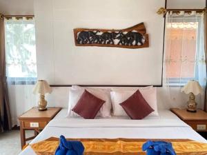 a bedroom with a large white bed with red pillows at Koh Chang Resort in Ko Chang