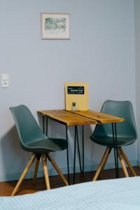 a desk with two chairs and a laptop on it at Mountain View Salzburg Apartments in Grödig