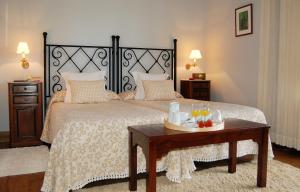Un dormitorio con una cama y una mesa con bebidas. en Quinta de Villanueva, en Colombres