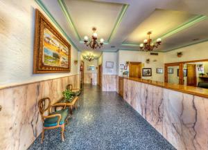 pasillo con paredes de mármol, mesa y sillas en Hotel Sandra, en Alcalá de Guadaira