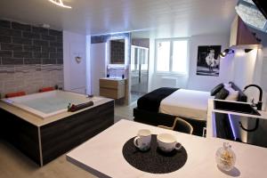 a bedroom with a bed and a tub in a room at Bulles Emotions in Arbois