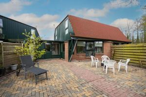 a patio with chairs and tables in front of a house at Tulip Marina in Nieuwe-Niedorp