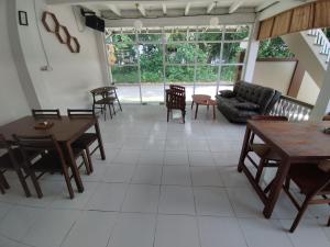 a living room with tables and chairs and a couch at Krui penginapan jokowi in Krui +27 photos