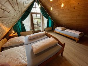 Un dormitorio abuhardillado con dos camas y una ventana. en Ferienhaus 33 Altmühlthal, en Kinding