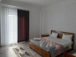a bedroom with a bed and a large window at Villa71 in Pogradec