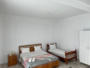 sypialnia z 2 łóżkami i szafką nocną w obiekcie Villa71 w mieście Pogradec