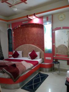 a bedroom with a large bed with a red headboard at Hotel Amar palace pachmarhi in Pachmarhī