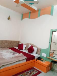 a bedroom with two beds and a ceiling fan at Hotel Amar palace pachmarhi in Pachmarhī