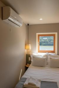 - une chambre avec un grand lit et une fenêtre dans l'établissement Quinta Torres de Azevedo by North Star Flats, à Sebolido