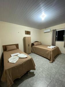 a room with two beds in a room at Pousada Lençóis Encantados - Centro de Barreirinhas in Barreirinhas