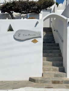 una escalera con una señal en el lateral de un edificio en Zisis Pension en Agios Stefanos
