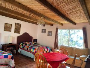 a bedroom with two beds and a table and a couch at Ventana Al Desierto in Real de Catorce