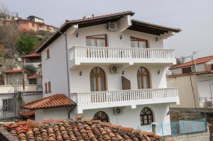 a white house with a balcony on top of a roof at Vila Malasi in Berat