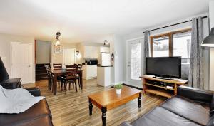 a living room with a couch and a flat screen tv at 16 Chemin Alpin in Stoneham