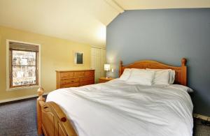 a bedroom with a large white bed and a window at 16 Chemin Alpin in Stoneham