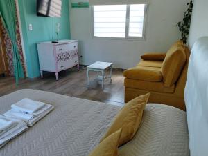 a bedroom with a bed and a couch and a chair at Esmeralda in Mar del Plata