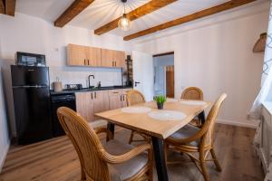 a kitchen with a wooden table with chairs and a black refrigerator at Middle Apartments in Braşov