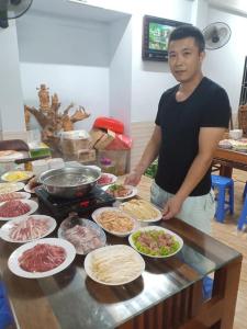 um homem parado em frente a um buffet de comida em Nhà Nghỉ Việt Hùng em Mai Châu