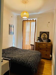 een slaapkamer met een bed, een dressoir en een raam bij Cozy apartment in a lively Nice district in Nice