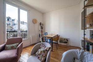 sala de estar con ventana grande y mesa en Nice apartment in the heart of Paris - Welkeys en París