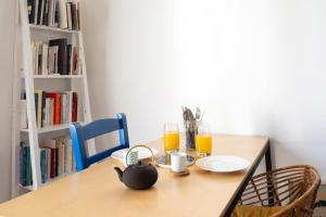una mesa con 2 vasos de zumo de naranja y un hervidor de agua. en Nice apartment in the heart of Paris - Welkeys en París