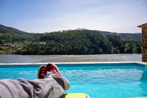 una persona con los pies al borde de una piscina en Quinta Torres de Azevedo by North Star Flats, en Sebolido