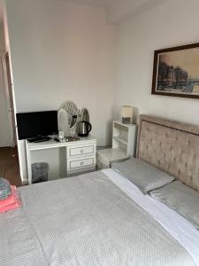a bedroom with a bed and a desk with a television at Barley Mow Hotel in Pontefract